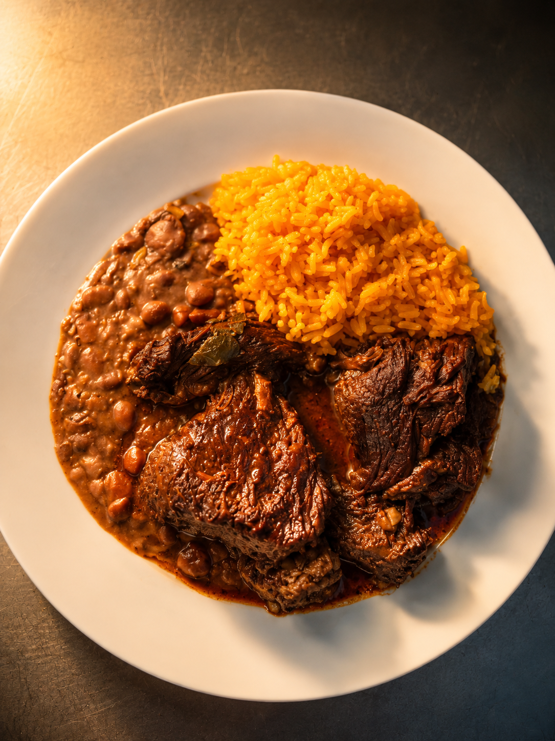 A plate of braised meat with beans and yellow rice